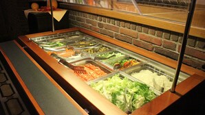 A buffet with various food options including sliced tomatoes, lettuce, and other vegetables. - Hotel Restaurant Haus Schieferstein (Dahlem)