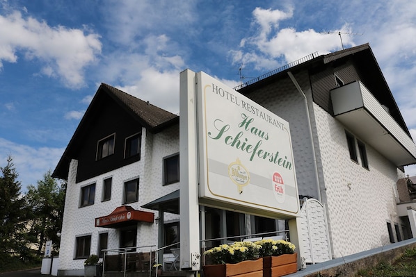 A hotel with a sign advertising a restaurant and a beer brand.