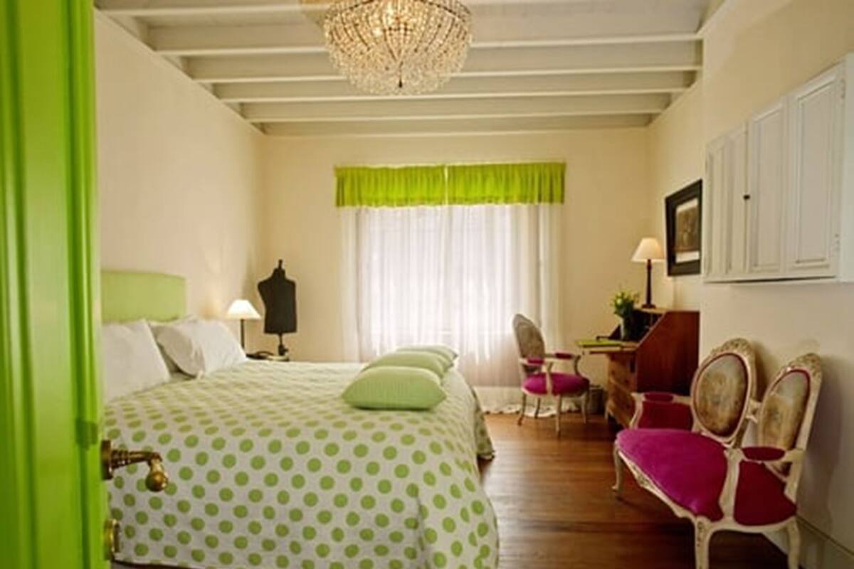 Une chambre à coucher avec un lit, une chaise, un bureau et un lustre.