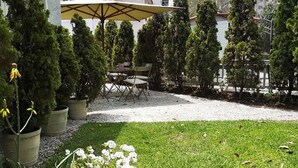 A patio area with a table and chairs under a canopy, surrounded by potted plants and a gravel path. - Quinta Miraflores Boutique Hotel (Lima)