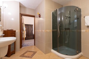 A modern bathroom with a glass-enclosed shower, a wooden vanity, and a white sink.