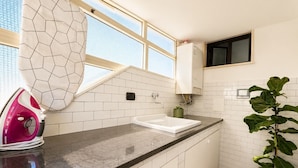 A kitchen with a countertop, sink, window, and a potted plant. - Domus Claudia - Holiday Homes (Siracusa)