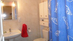 Ein Badezimmer mit Waschbecken, Toilette und Spiegel.