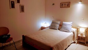 Ein Schlafzimmer mit einem Bett, zwei Nachttischlampen, einem Sessel und einem kleinen Tisch.