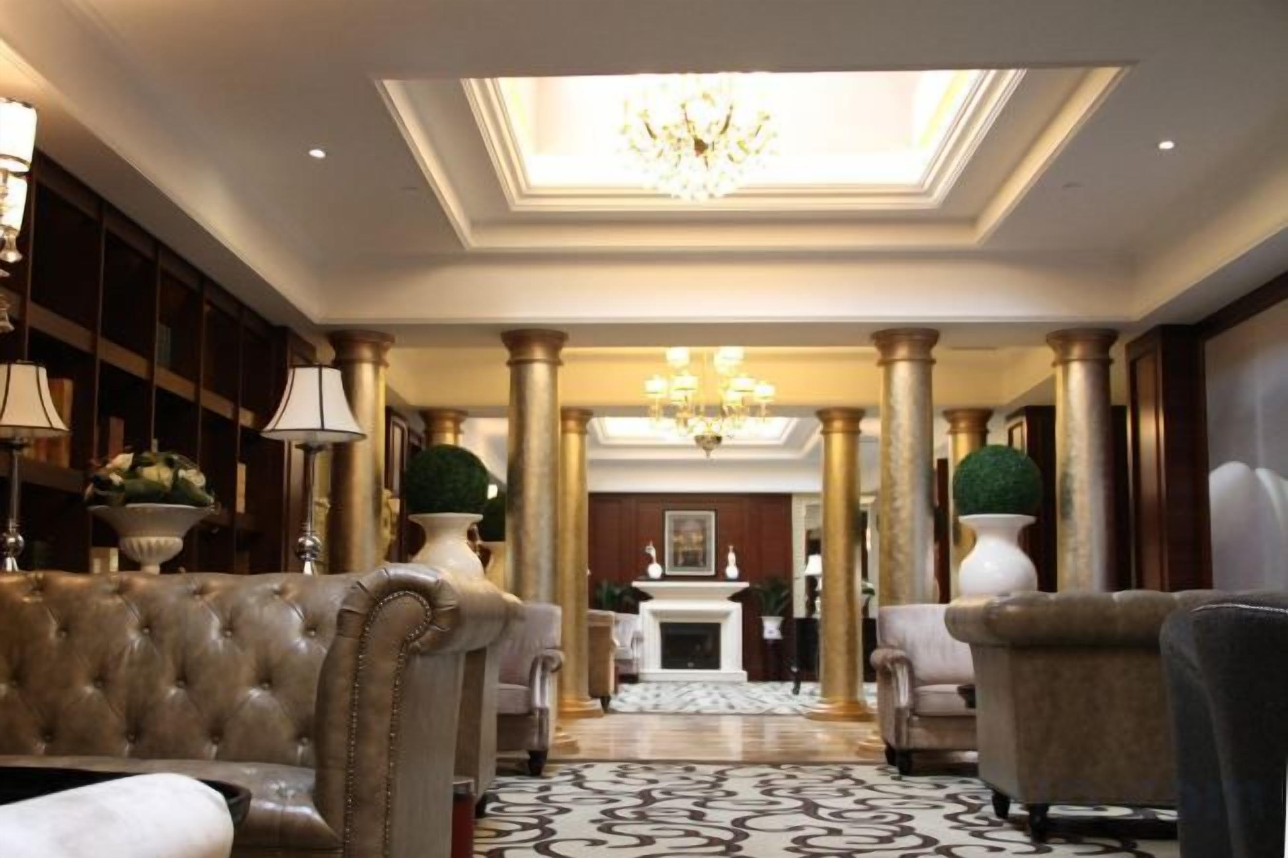 A grand lobby with a chandelier, columns, and plush seating.