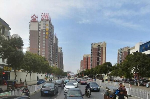 A busy urban street lined with high-rise buildings, vehicles, and pedestrians. - Binzhou International Garden Hotel (Binzhou)
