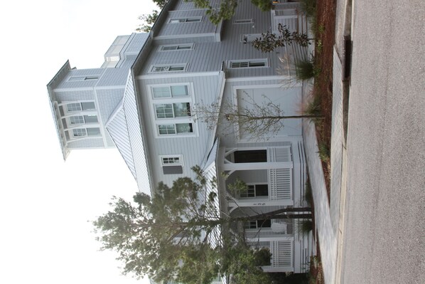 A multi-story building with a symmetrical facade, large windows, and a central entrance with a porch.
