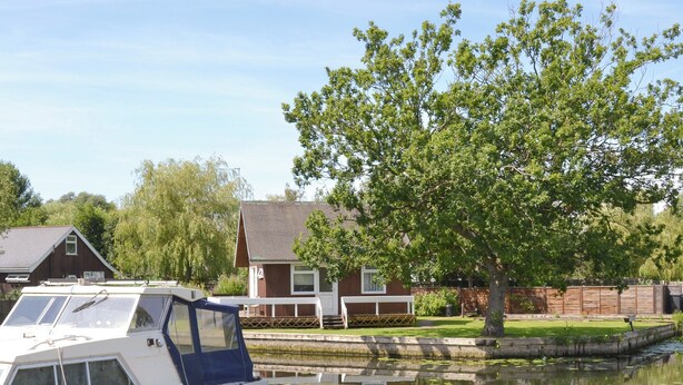 Kelluva talo oli ankkuroitu lähelle lammikkoa, jonka pinnalla kellui lumpeenlehtiä. Taloa ympäröivät puut ja puinen aita.