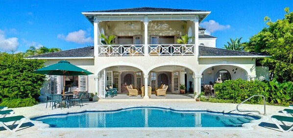 A two-story house with a swimming pool, outdoor seating, and a balcony. - Villa Oceana (Holetown)