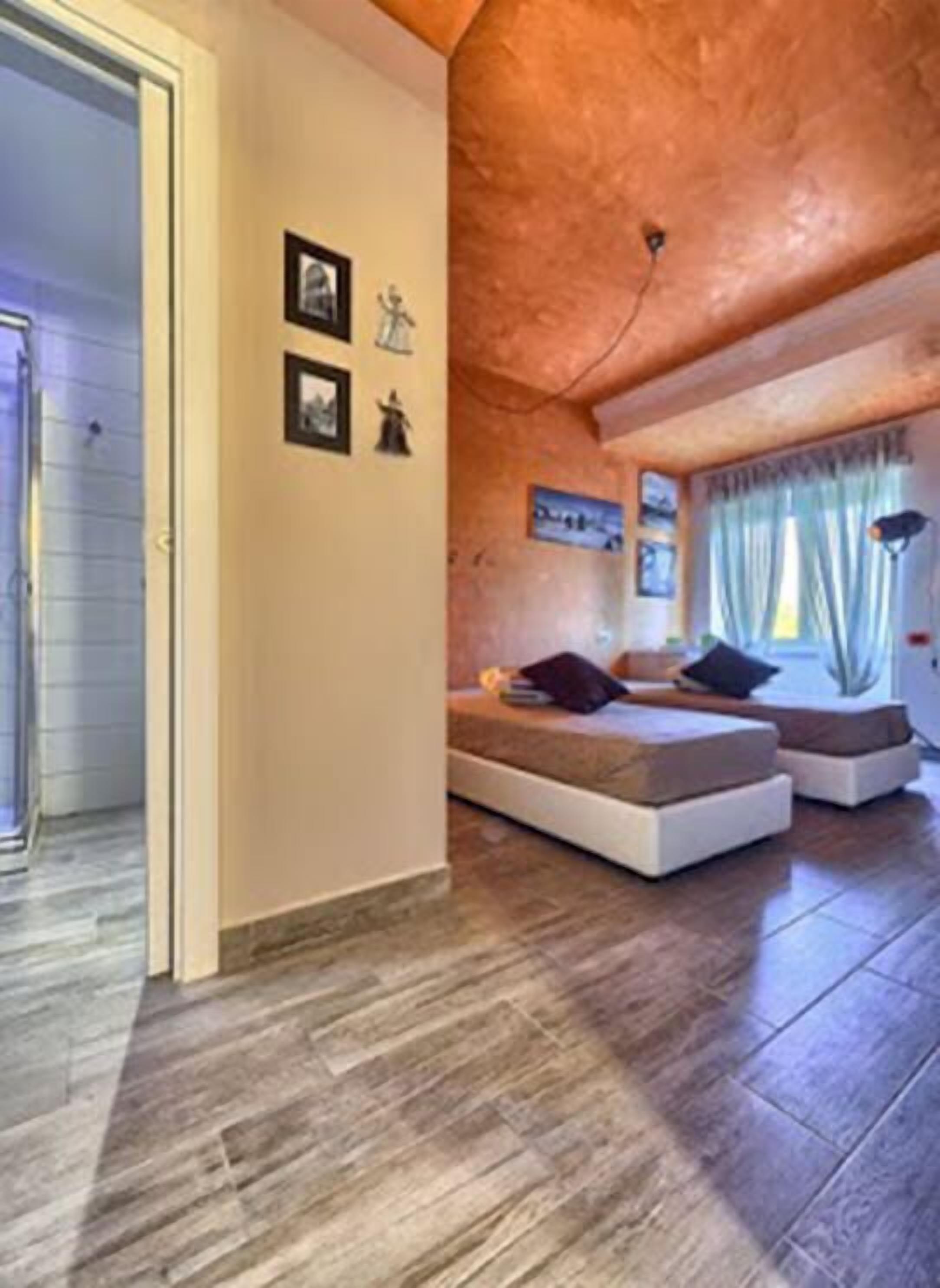 Un salón acogedor con techo alto y chimenea. Hay dos sofás y una mesa de centro.