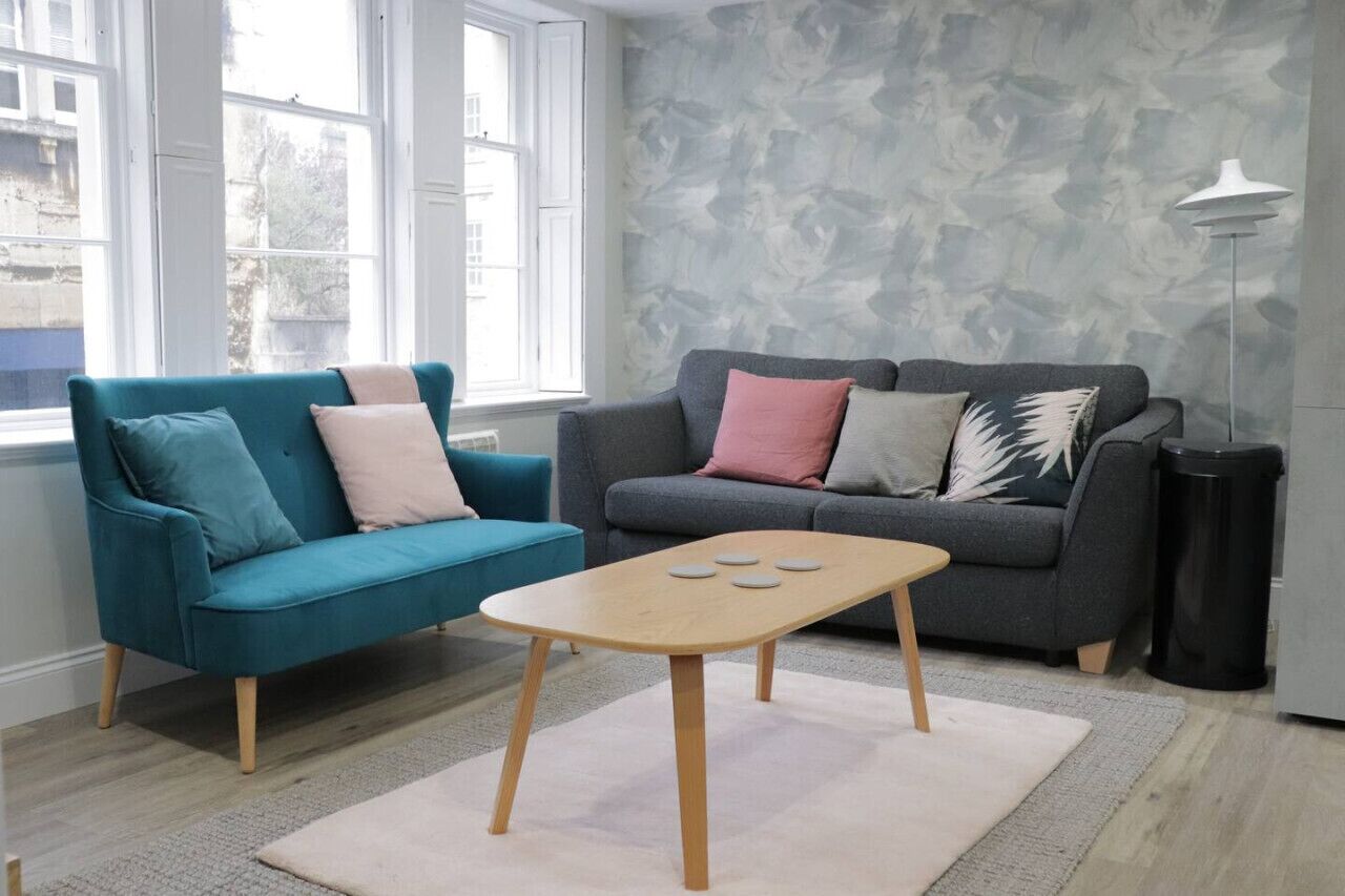 A living room with two sofas, a coffee table, and a floor lamp.