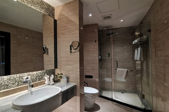Un baño moderno con un lavamanos grande, espejo y cabina de ducha de vidrio.