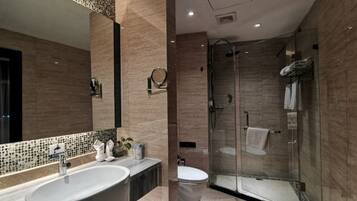 Un baño moderno con un lavamanos grande, espejo y cabina de ducha de vidrio.