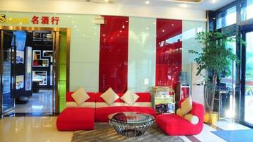 Un moderno vestíbulo con un sofá rojo, una mesa de centro de vidrio y un gran ventanal.