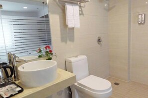 A modern bathroom with a large sink, toilet, and shower. - Wuhu Business Hotel (Shiyan)