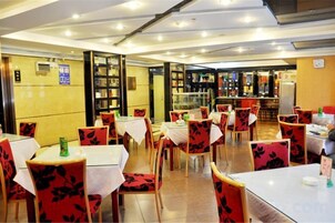 Un restaurante con mesas, sillas, una barra y una barra de servicio.