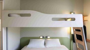 Una cama individual con escalera, una mesita de noche con lámpara y un cabecero verde.