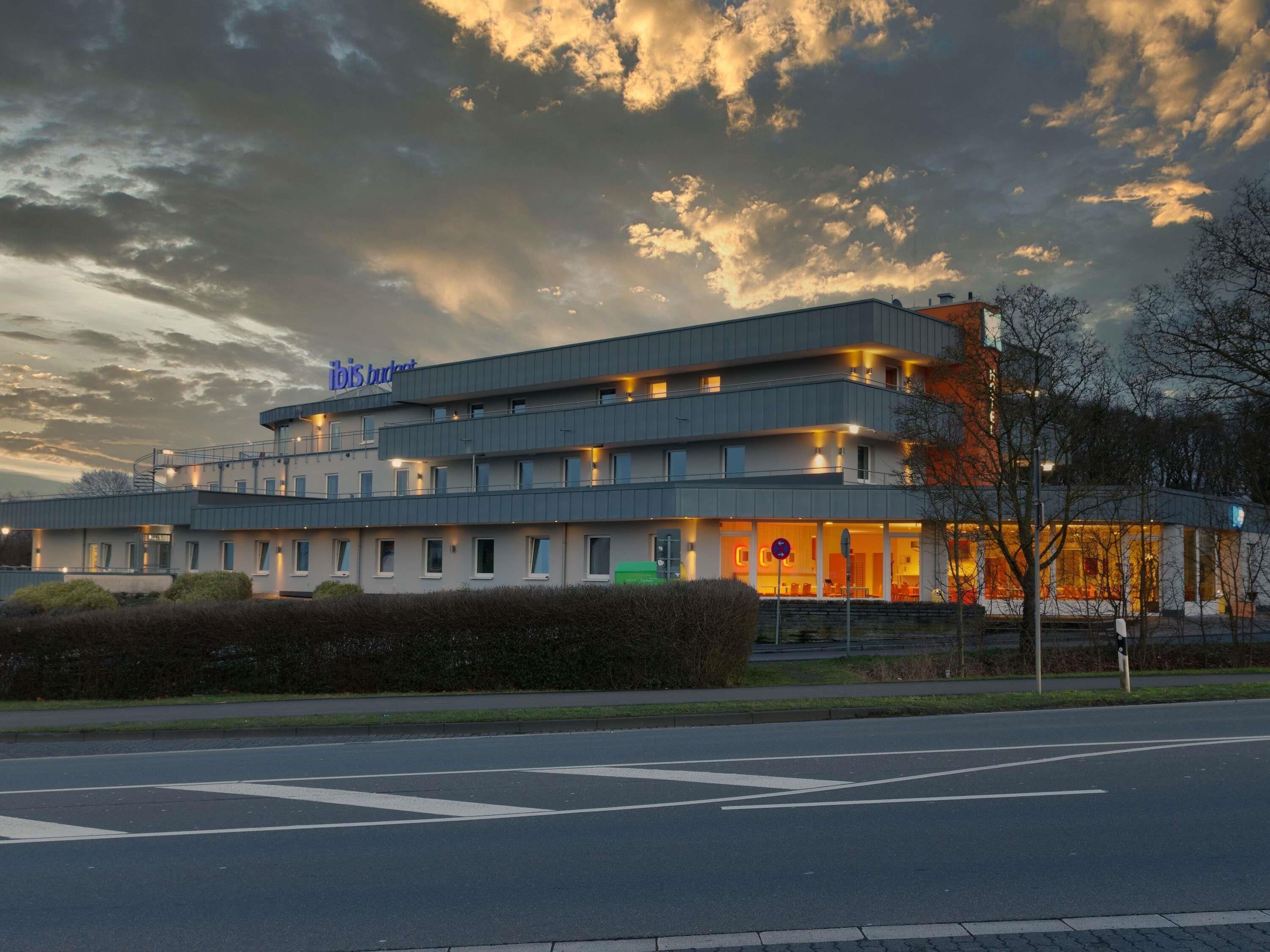 A multi-story hotel with a modern design, featuring a prominent 'ibis budget' sign.