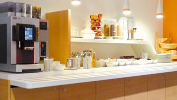 A breakfast bar with a coffee machine, various food containers, and utensils.