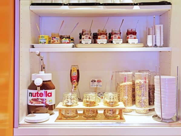 Una variedad de alimentos, incluyendo tarros de miel, conservas de albaricoque y Nutella.