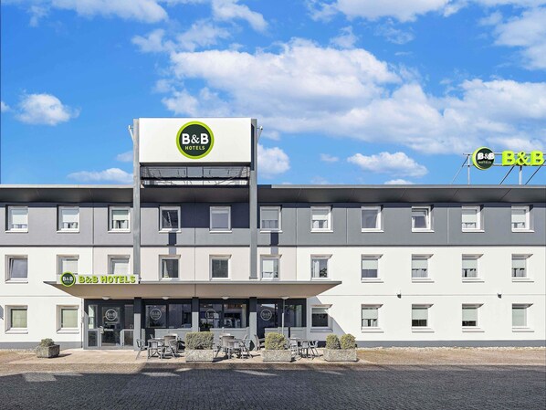 A B&B hotel with a modern facade, multiple windows, and outdoor seating area.