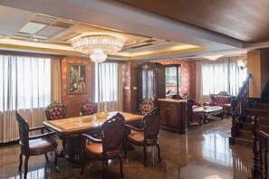 A formal dining room with a large table, ornate chairs, and a chandelier. - Seaside City Resort Village (Wuhan)