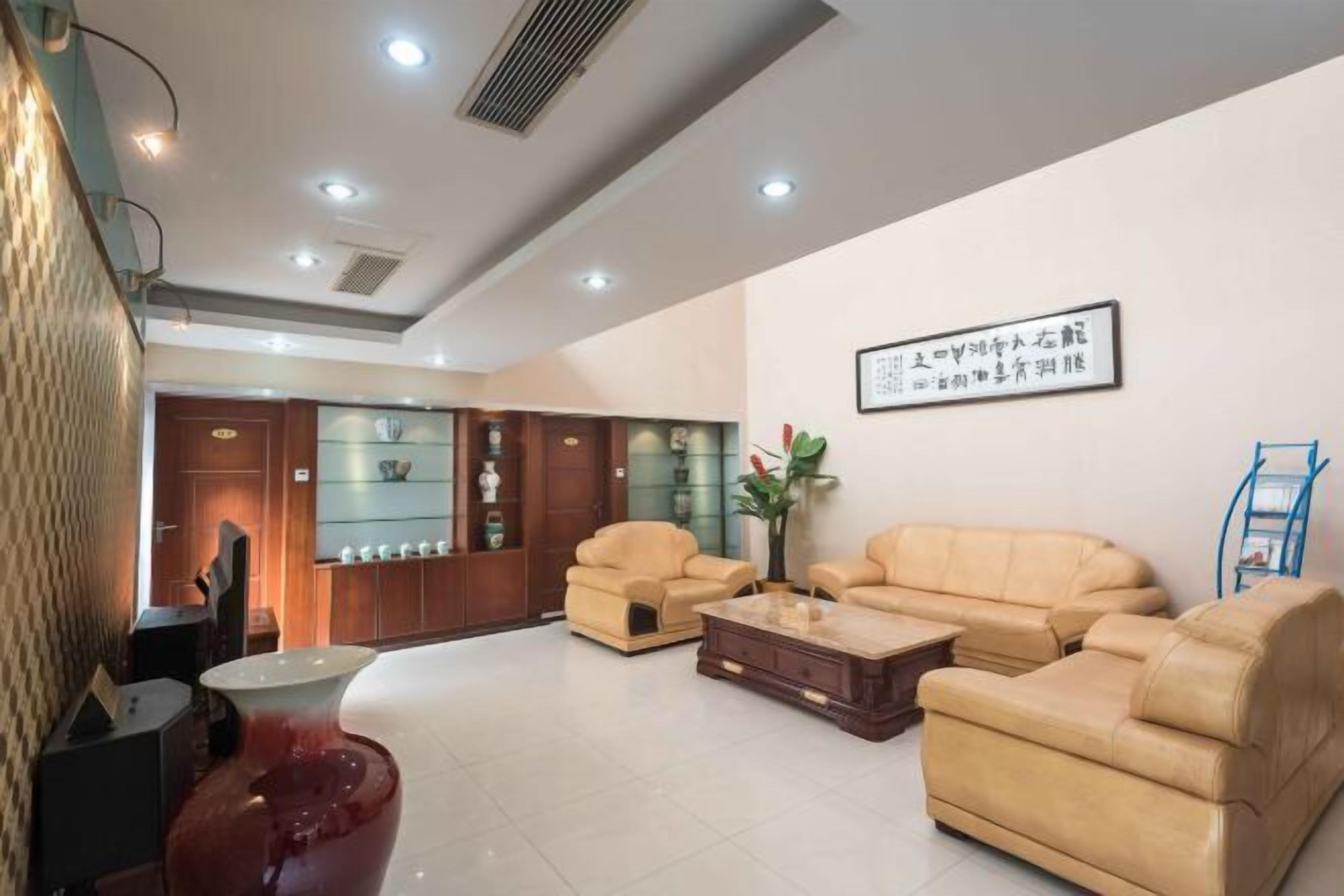A spacious living area with a sofa set, a coffee table, and a decorative vase.