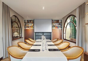 Conference room with a long table, leather chairs, and bookshelves.