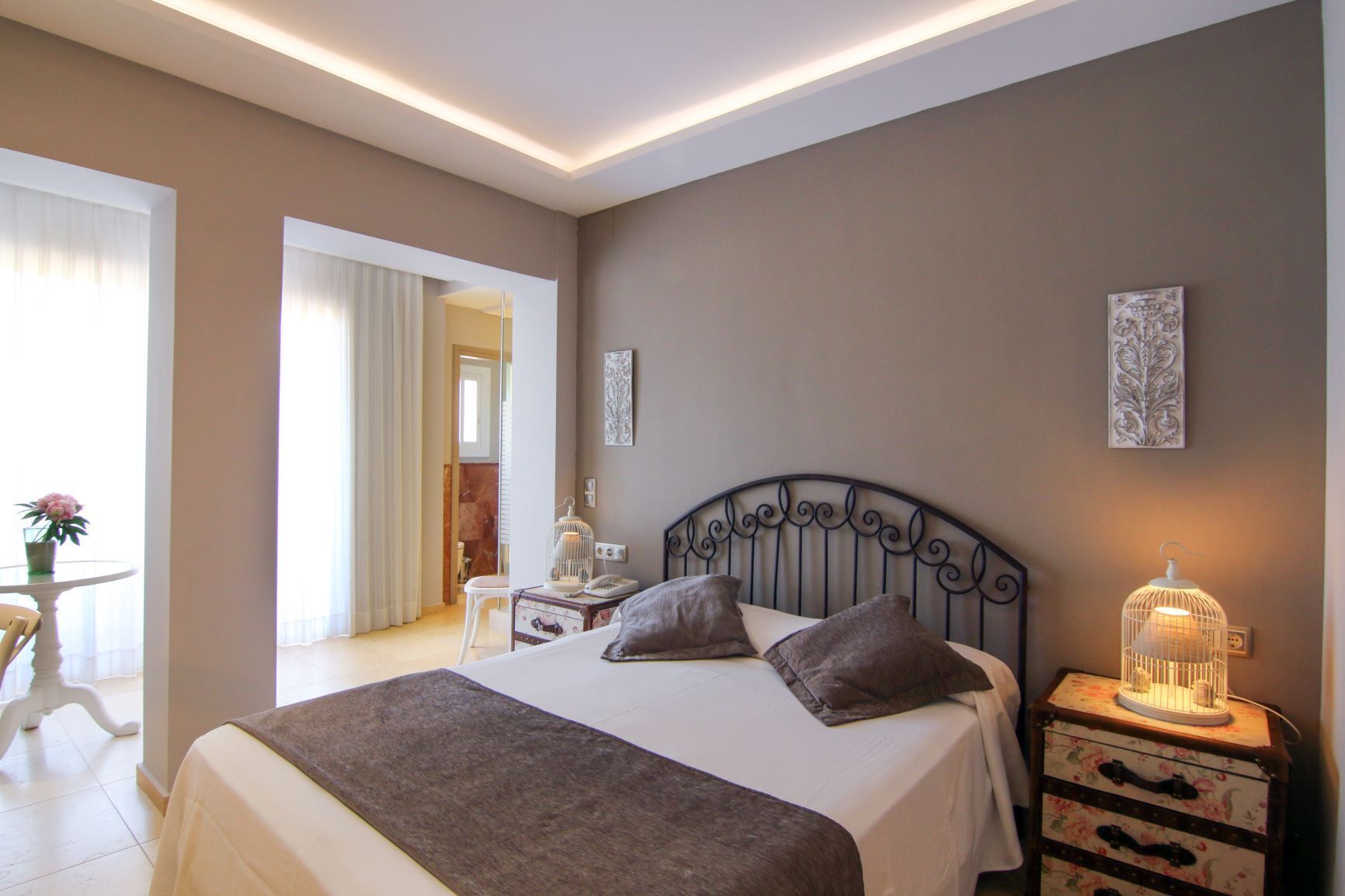 Um quarto com uma cama grande, mesas de cabeceira e uma luminária.