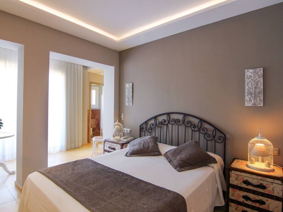 Um quarto com uma cama grande, mesas de cabeceira e uma luminária.