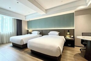 Habitación de hotel con dos camas, un escritorio y una silla.