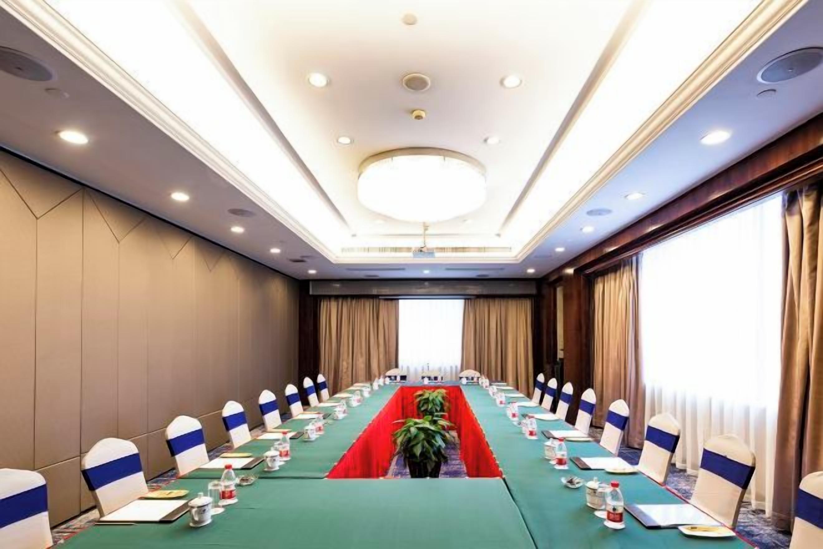 A conference room with a long table, chairs, and a chandelier.