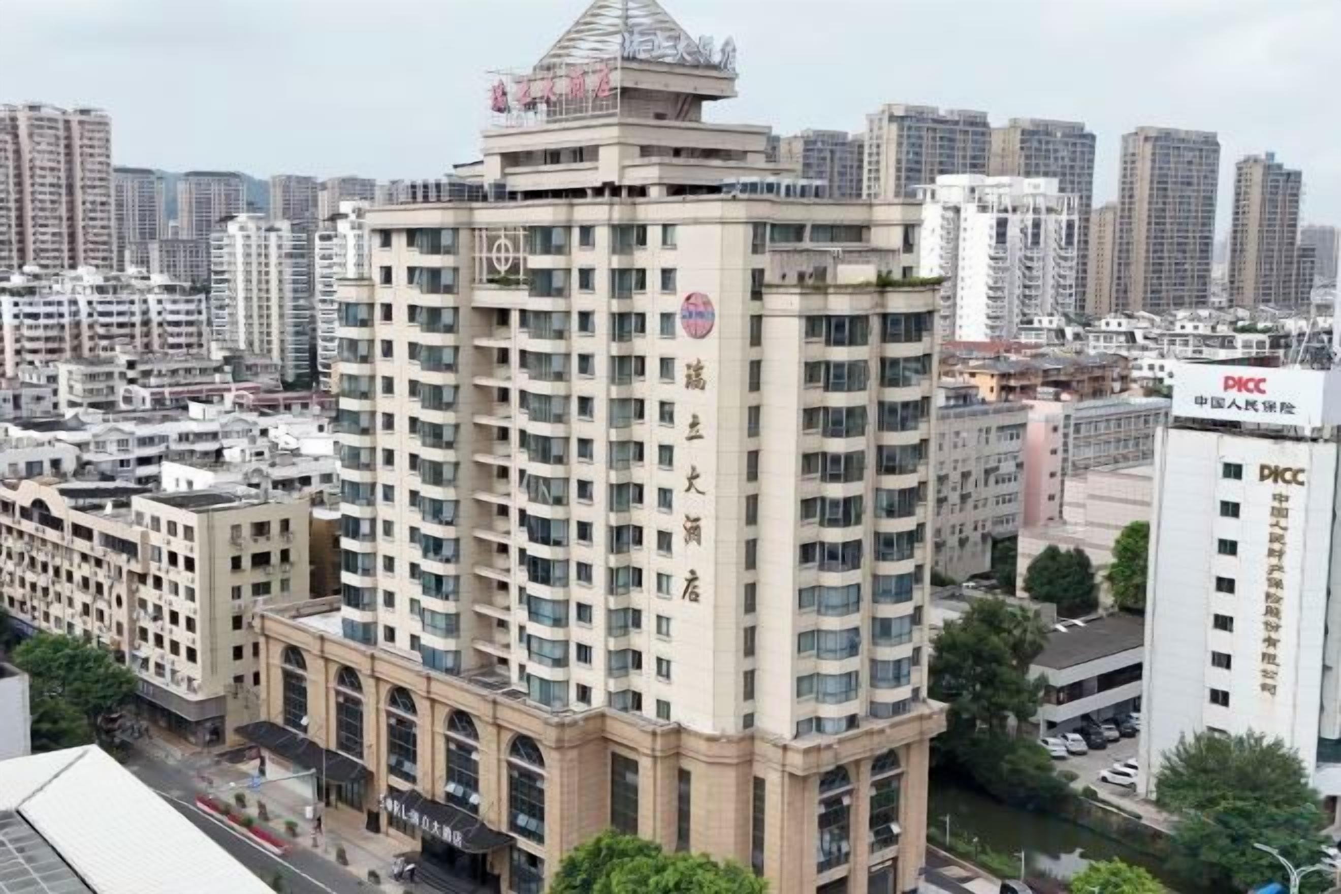 A high-rise hotel with multiple floors, a prominent entrance, and a rooftop structure.