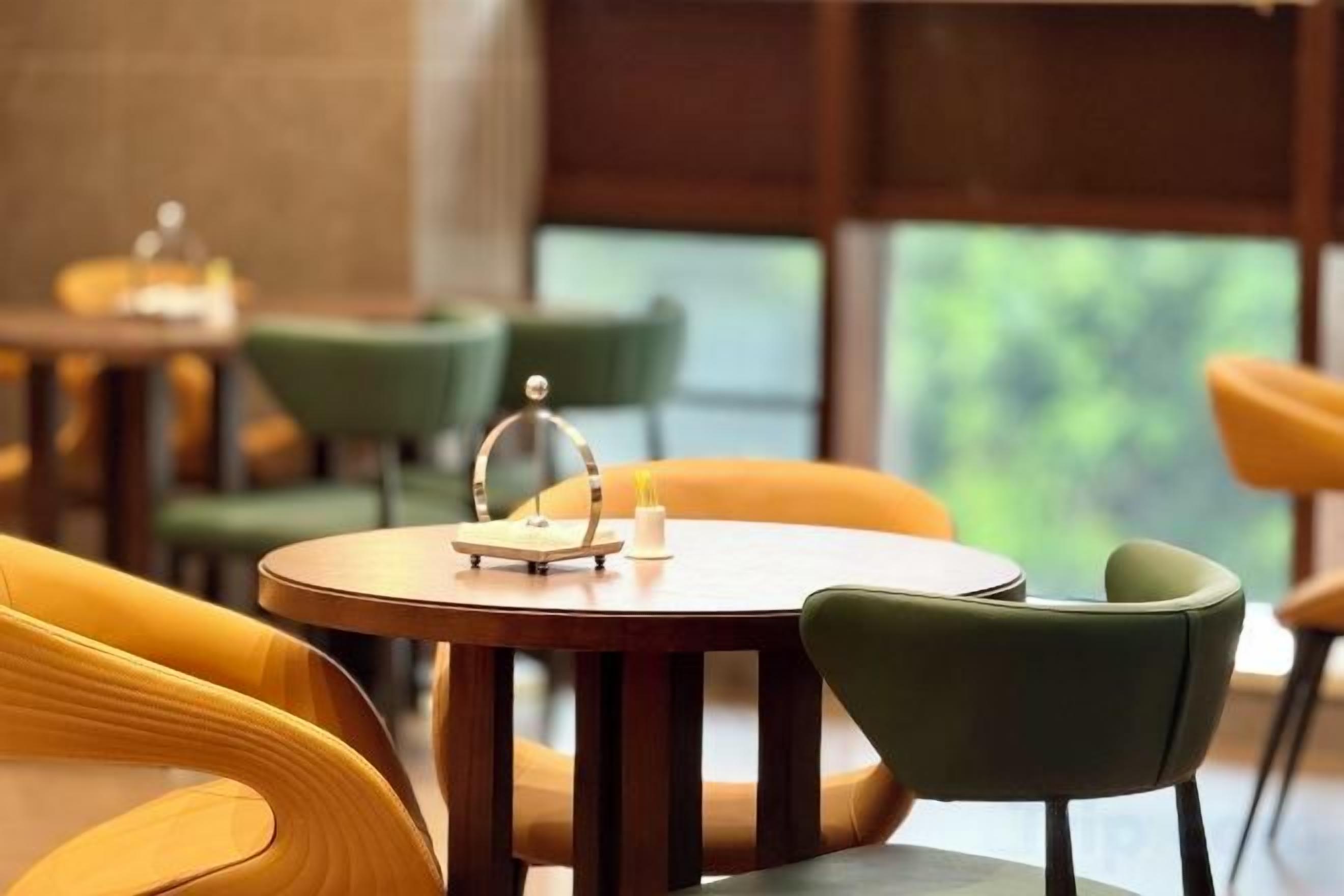 A restaurant with round tables and chairs, some with a glass dome centerpiece.