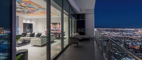 A modern living room with a city view, large windows, and contemporary furniture.