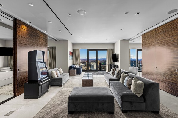 Uma sala de estar moderna com um conjunto de sofá, uma TV de tela plana e vista para a cidade.