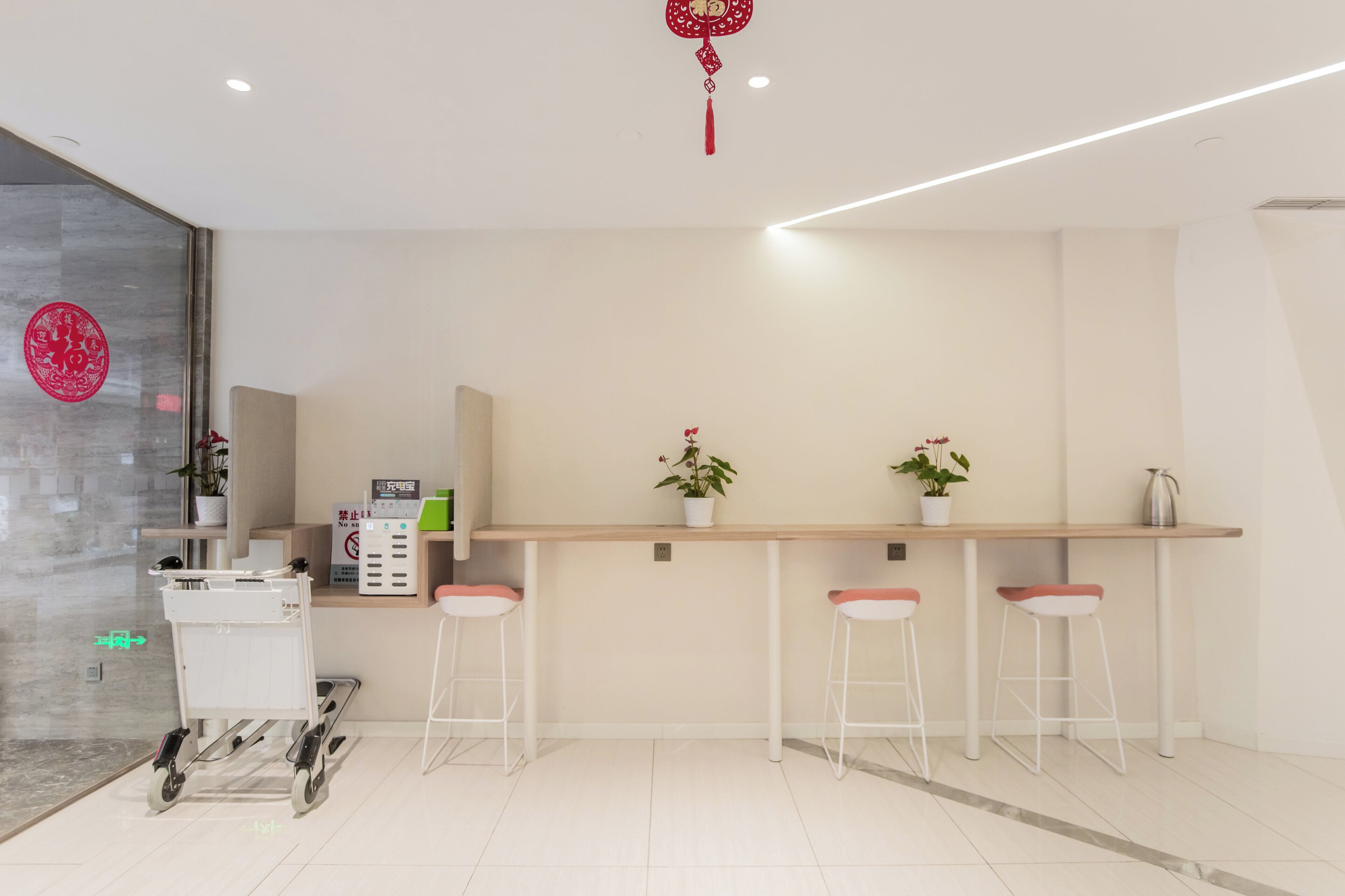 A modern reception area with a counter, seating, and a wheelchair-accessible cart.