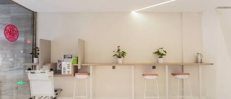 A modern reception area with a counter, seating, and a wheelchair-accessible cart.