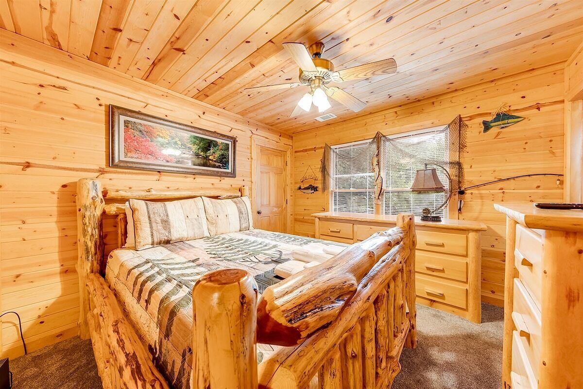 Camera da letto in un rifugio di legno con un letto, una scrivania e una finestra.