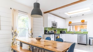 A modern kitchen with a wooden dining table, blue chairs, and a built-in oven. - Excellent walkable location - Bright & Modern, Pets Welcome! (Portland)
