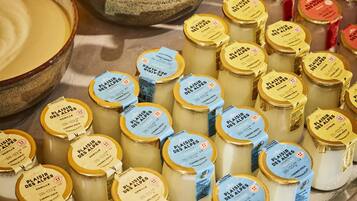 Una exhibición de varios productos lácteos, incluyendo frascos de queso y un tazón de sopa.