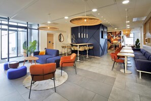 Un intérieur moderne avec des coins salon, des tables et une grande fenêtre qui laisse entrer la lumière naturelle.