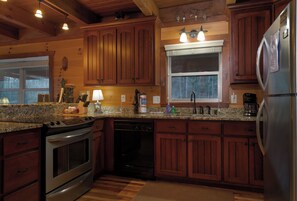 Enjoy cooking in this well-equipped kitchen with a window offering a view of the outdoors.