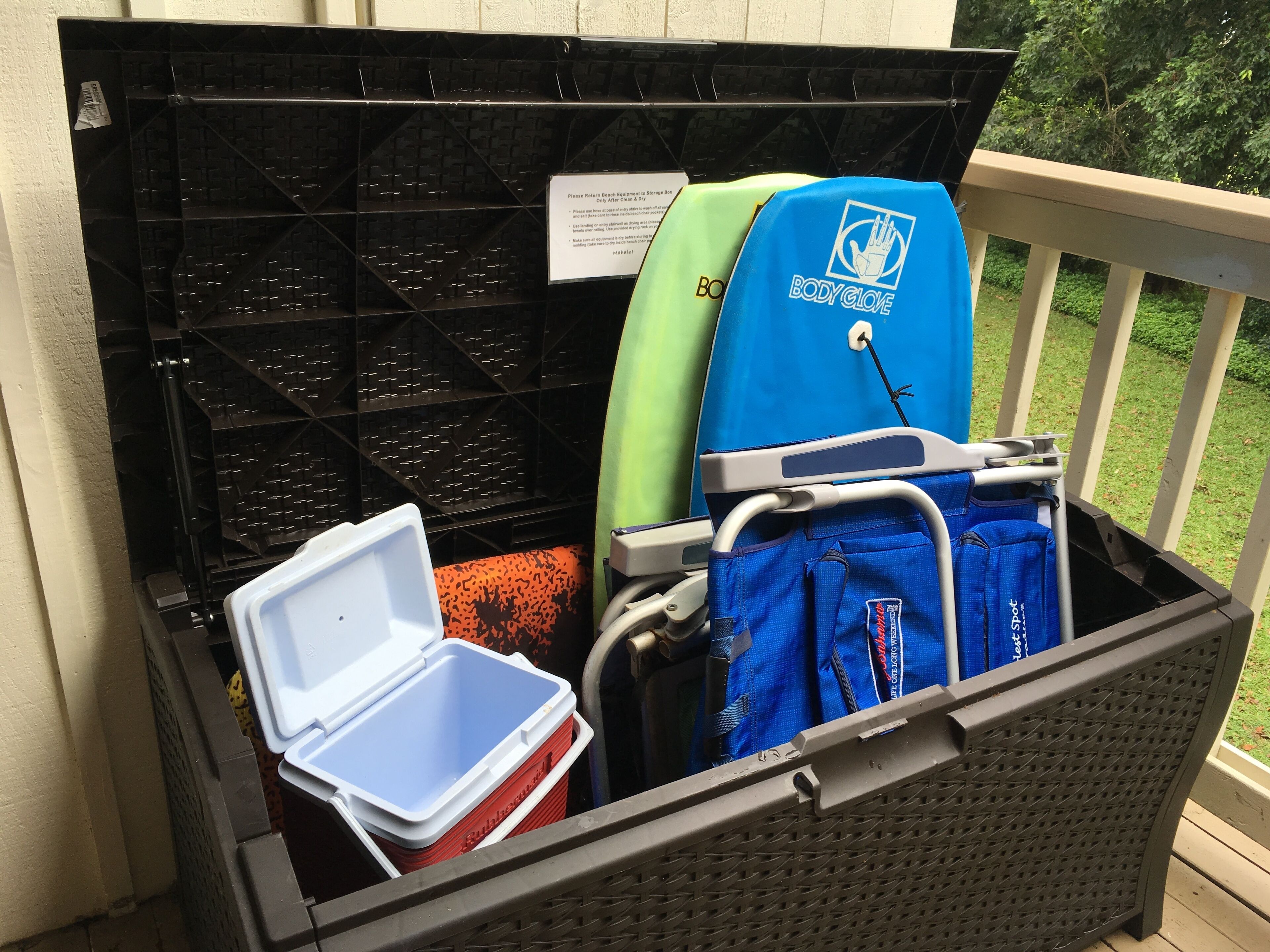 A storage bin filled with various items including a blue towel, a green towel, and a red container.