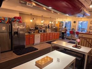 A modern kitchen with stainless steel appliances, wooden cabinets, and pendant lighting. - Hostel du Nord (Duluth)