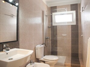 Een douche, een haardroger, een bidet, handdoeken