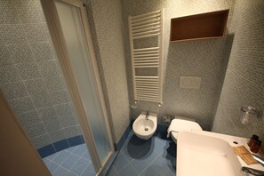 Een douche, een haardroger, een bidet, handdoeken