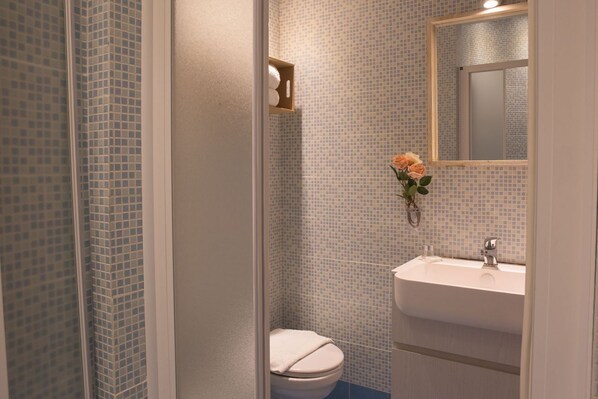 Un baño con inodoro, lavabo y espejo.