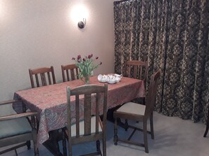 A dining table with a patterned tablecloth, surrounded by wooden chairs with cushioned seats. - Cosy and stylish home, convenient location for exploring Fermanagh Lakelands (Lisbellaw)