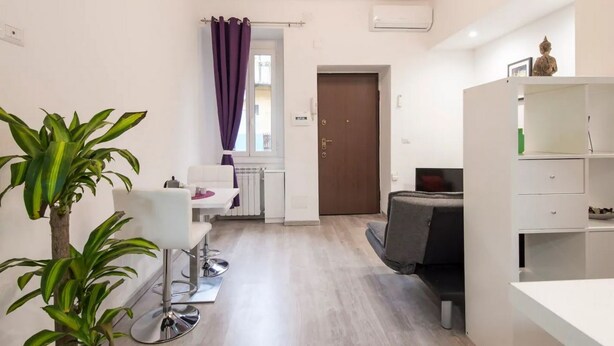 Ein stilvolles, helles Zimmer mit Essbereich, einer Couch und einem kleinen Tisch.